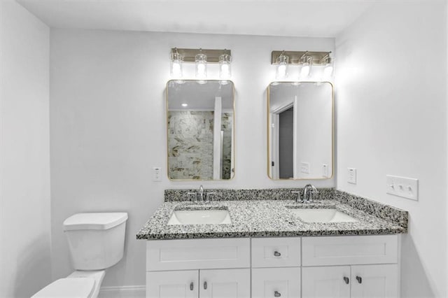 bathroom with double vanity, a sink, and toilet