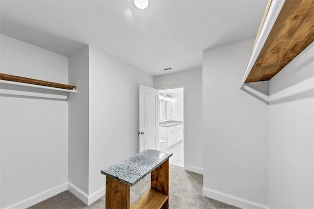walk in closet with visible vents and carpet