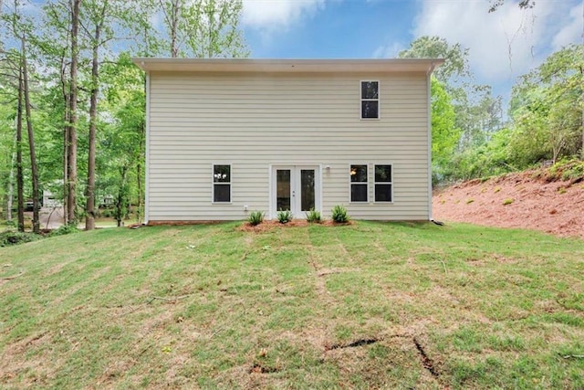 back of property with a yard and french doors