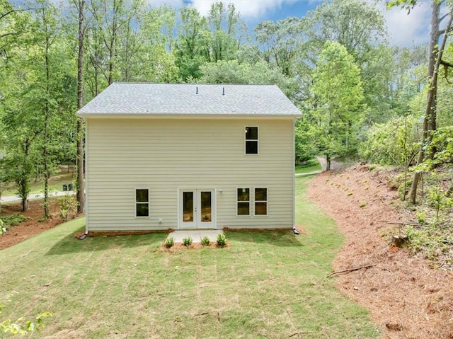 rear view of house featuring a lawn and french doors
