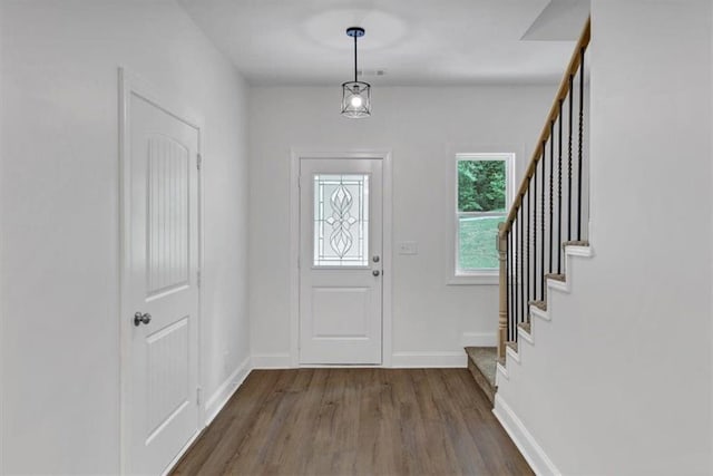 entrance foyer featuring baseboards, dark wood finished floors, and stairway