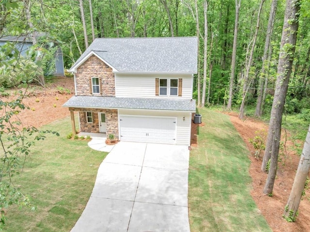 view of front of home featuring a front yard, stone siding, roof with shingles, an attached garage, and driveway