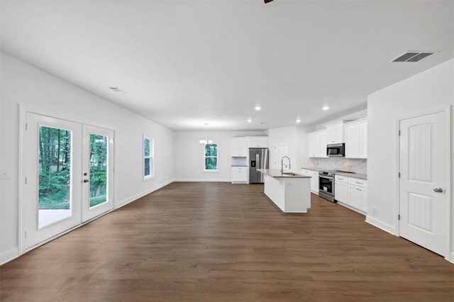 kitchen with an island with sink, stainless steel appliances, open floor plan, recessed lighting, and visible vents