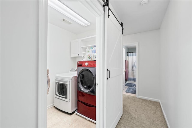 laundry area with cabinet space, washer and dryer, a barn door, and baseboards