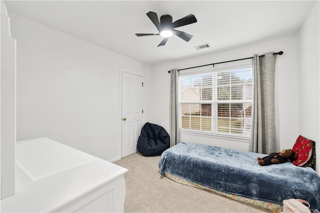 bedroom with light colored carpet and a ceiling fan