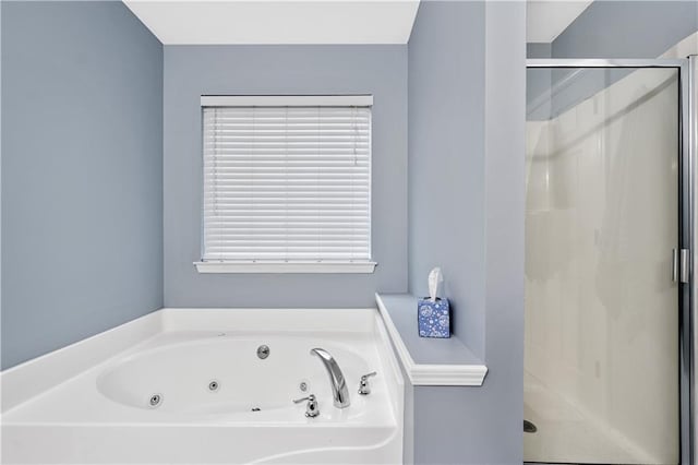 bathroom with a shower stall and a tub with jets