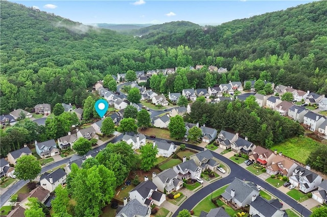 view of property location featuring nearby suburban area and a forest