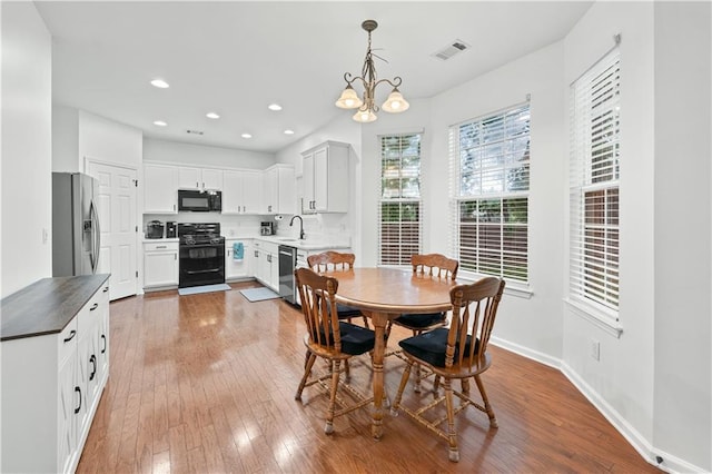 dining space featuring wood-type flooring, a chandelier, baseboards, and recessed lighting