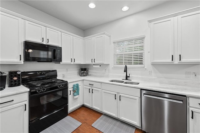 kitchen featuring black appliances, a sink, white cabinetry, recessed lighting, and dark wood-style flooring