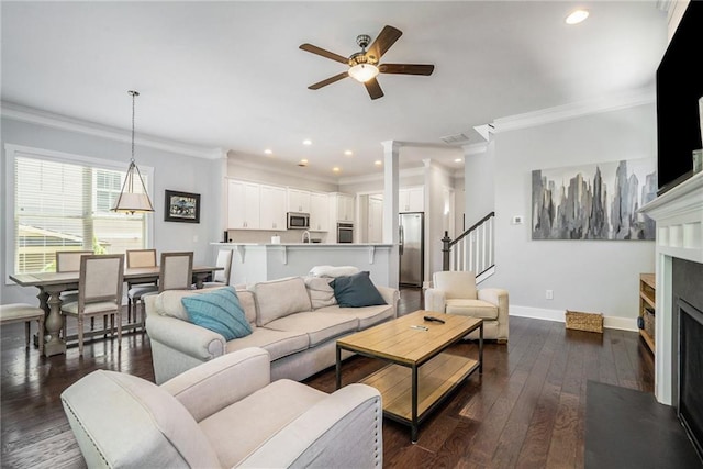 647 E Ave NE, Atlanta, GA 30312 - living room with a ceiling fan, crown molding, a fireplace with flush hearth, baseboards, and dark wood-type flooring