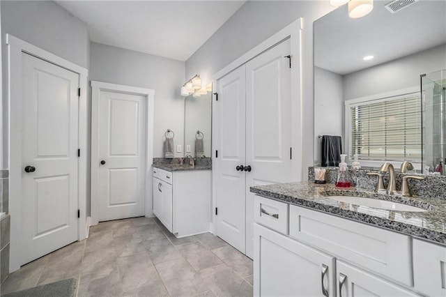 647 E Ave NE, Atlanta, GA 30312 - bathroom with visible vents, two vanities, a sink, and a stall shower