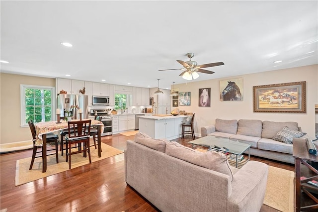 living room with ceiling fan and light hardwood / wood-style flooring