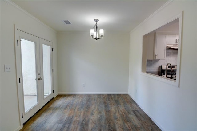 3263 Long Iron Pl, Lawrenceville, GA 30044 - unfurnished dining area with ornamental molding, dark wood finished floors, plenty of natural light, a chandelier, and french doors