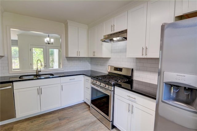 3263 Long Iron Pl, Lawrenceville, GA 30044 - kitchen featuring appliances with stainless steel finishes, under cabinet range hood, a sink, dark countertops, and white cabinets