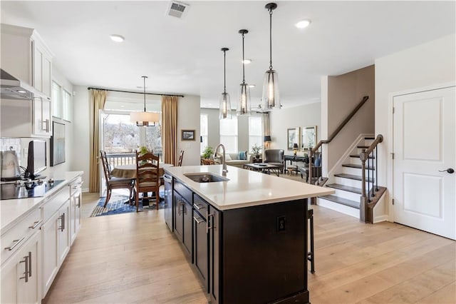 15 Lakeside Way, Cartersville, GA 30121 - kitchen with a sink, black electric cooktop, light countertops, white cabinets, and light wood-style flooring