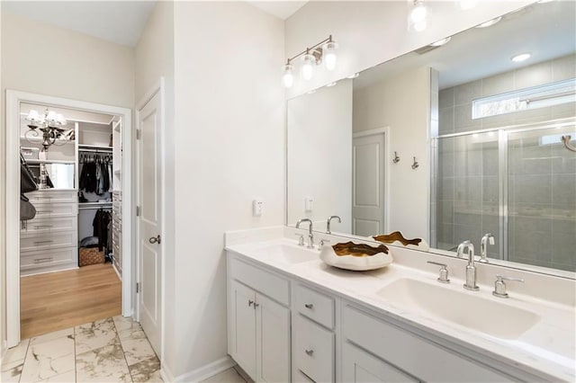 15 Lakeside Way, Cartersville, GA 30121 - bathroom with marble look tile flooring, double vanity, a shower stall, a spacious closet, and baseboards