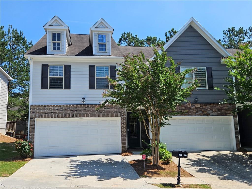 2141 Spikerush Way, Buford, GA 30519 - view of front of home with an attached garage, concrete driveway, and brick siding