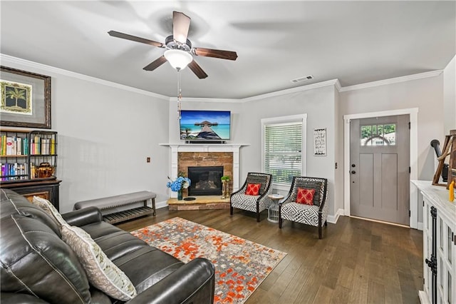 4571 Academy St, Acworth, GA 30101 - living room featuring a stone fireplace, dark wood-type flooring, ceiling fan, and crown molding