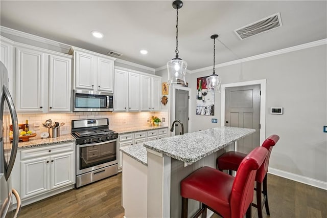 4571 Academy St, Acworth, GA 30101 - kitchen featuring appliances with stainless steel finishes, ornamental molding, decorative backsplash, white cabinets, and dark wood finished floors