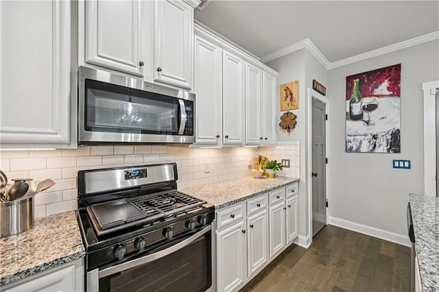 4571 Academy St, Acworth, GA 30101 - kitchen with stainless steel appliances, dark wood-style flooring, ornamental molding, white cabinets, and light stone counters