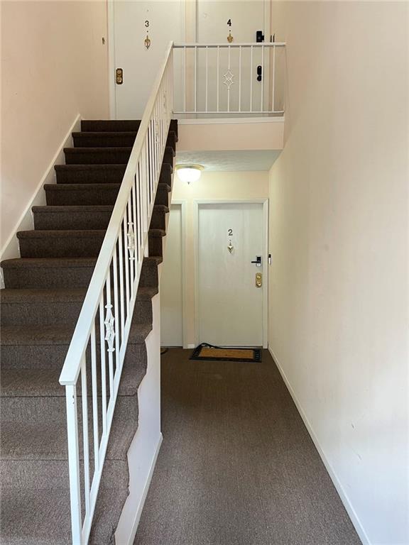 stairs with carpet floors and a high ceiling