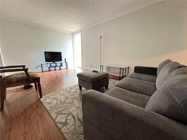 living room with ornamental molding, wood-type flooring, and a textured ceiling