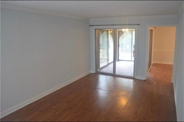 spare room with dark wood-type flooring and crown molding