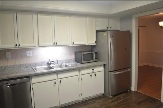 kitchen with sink, stainless steel appliances, tasteful backsplash, white cabinets, and dark hardwood / wood-style flooring