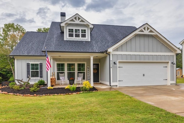 view of front of house featuring a garage, a front lawn, and a porch