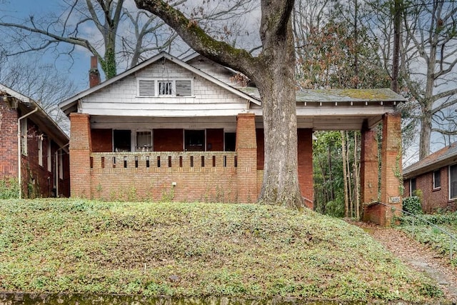 bungalow featuring brick siding