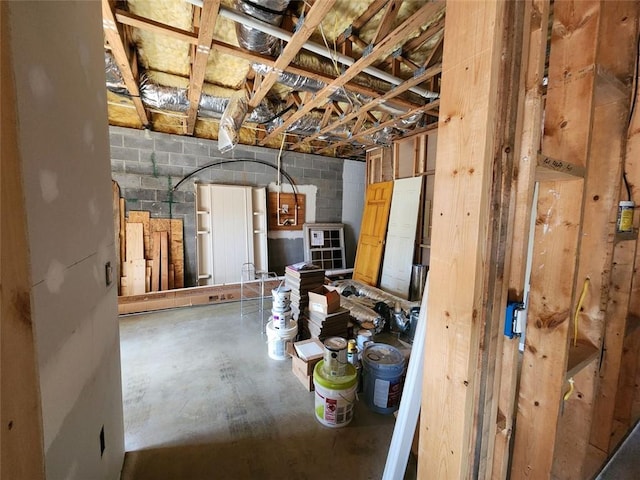 misc room with concrete flooring and concrete block wall