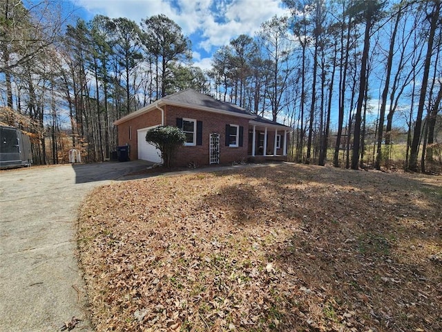 ranch-style house featuring driveway, brick siding, and an attached garage