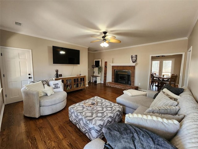 living room featuring dark wood-style floors, crown molding, visible vents, and a ceiling fan