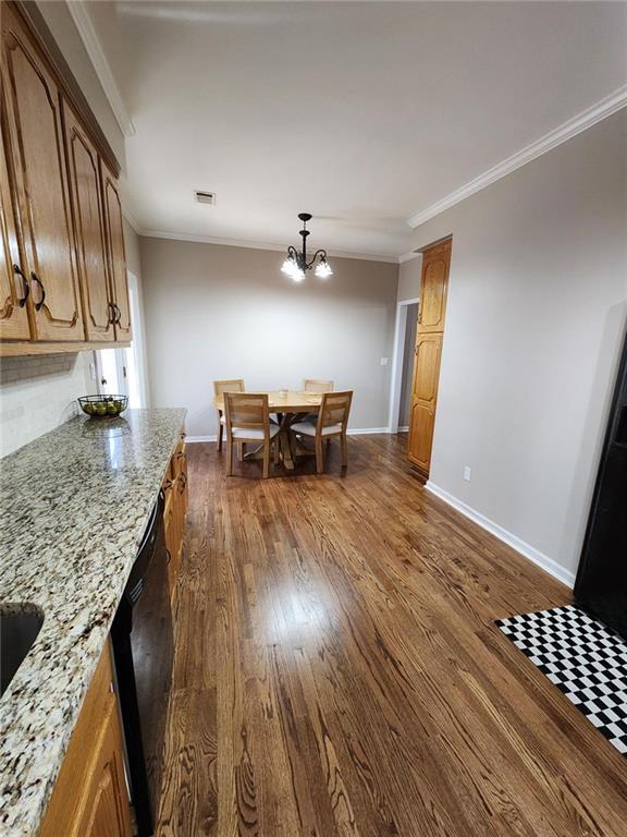 dining room with baseboards, dark wood finished floors, and crown molding