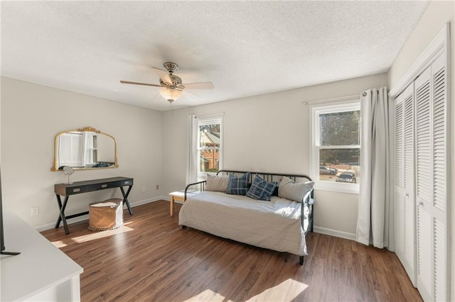 living room with dark hardwood / wood-style floors, ceiling fan, and a healthy amount of sunlight