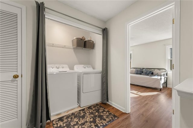 laundry area featuring washer and clothes dryer and hardwood / wood-style floors