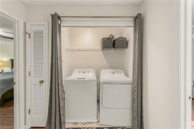 washroom featuring washer and dryer, a textured ceiling, and hardwood / wood-style flooring