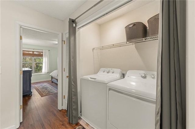 laundry area with dark hardwood / wood-style floors and washing machine and clothes dryer