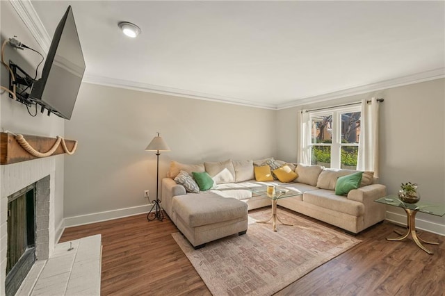 living room featuring dark hardwood / wood-style floors, crown molding, and a fireplace