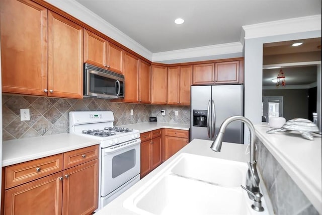 kitchen featuring ornamental molding, appliances with stainless steel finishes, tasteful backsplash, and sink