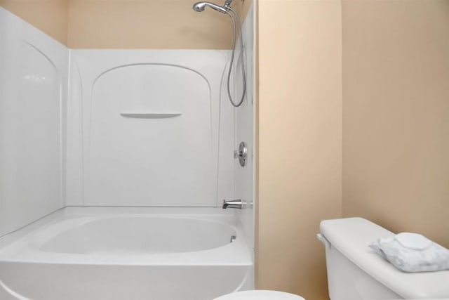 bathroom featuring washtub / shower combination and toilet