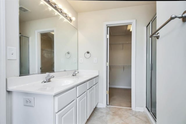 bathroom with tile patterned flooring, vanity, and walk in shower