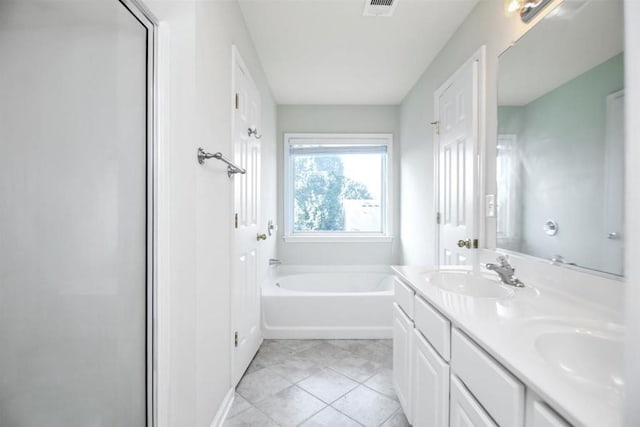 full bathroom with double vanity, visible vents, tile patterned floors, a sink, and a bath