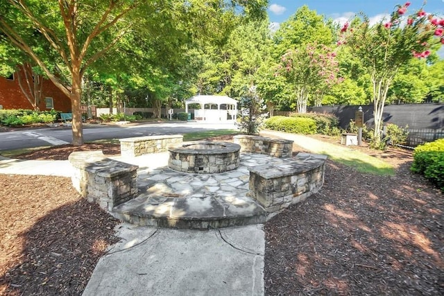 view of patio with an outdoor fire pit and fence