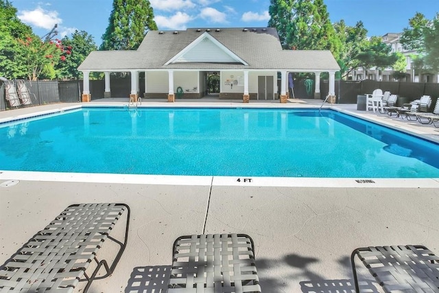 community pool featuring a patio area and fence