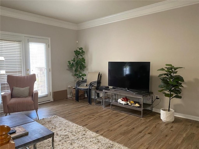 living area with baseboards, wood finished floors, and crown molding