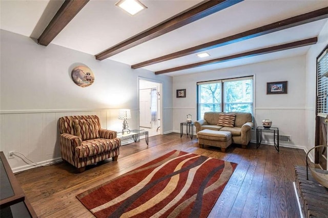 living room featuring hardwood / wood-style floors, a wainscoted wall, and beam ceiling