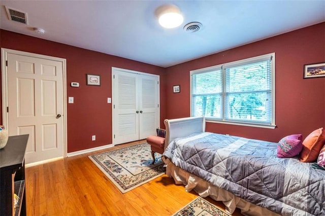 bedroom featuring wood finished floors, a closet, and baseboards