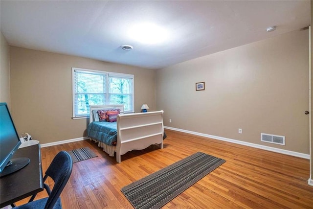 bedroom with wood finished floors and baseboards