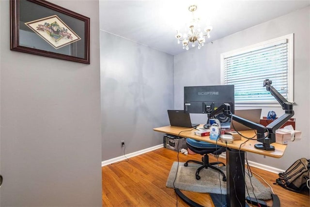 home office featuring wood finished floors, a chandelier, and baseboards